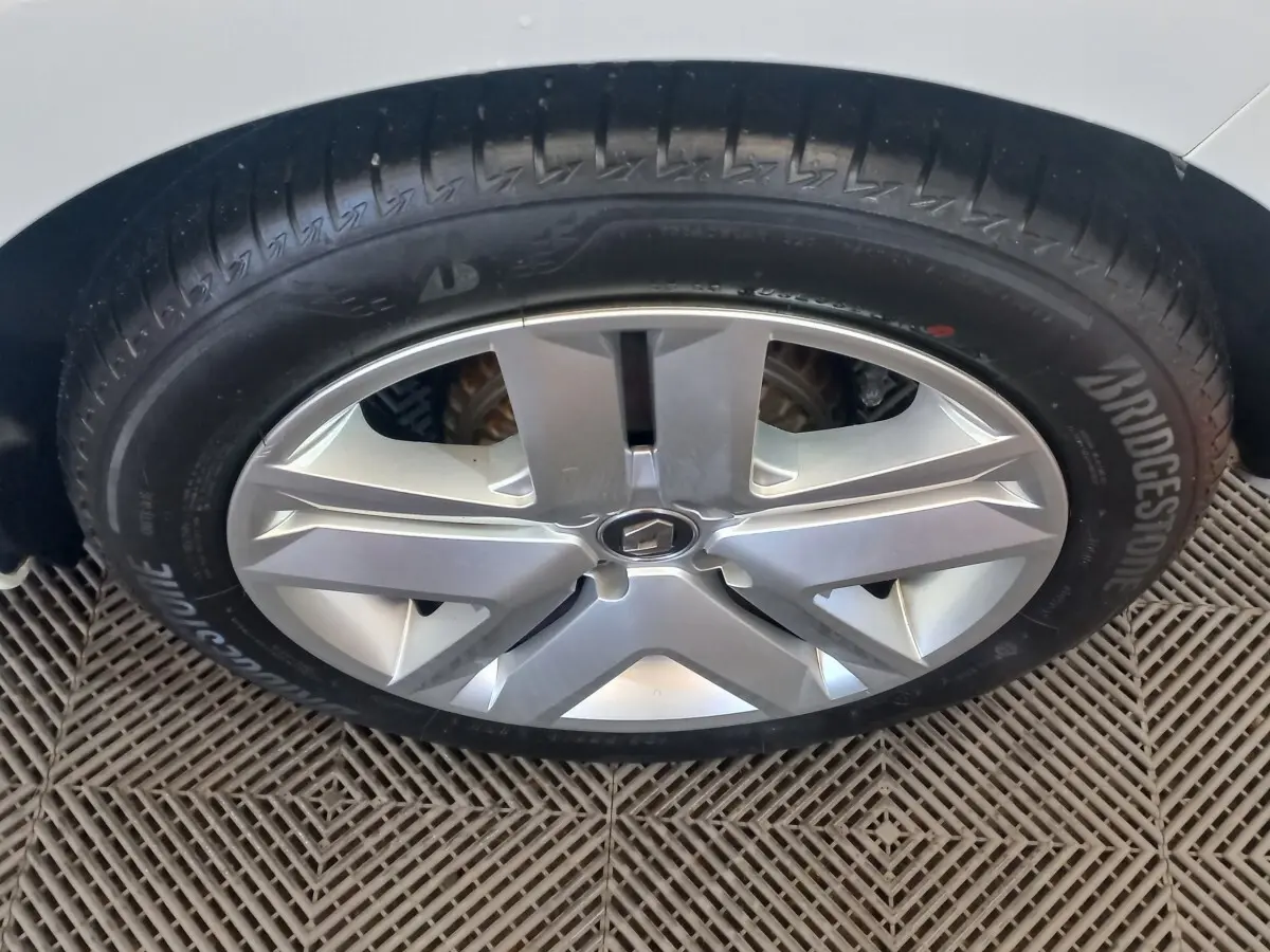 Gros plan sur la roue avant droite de la Renault Clio Business blanche, avec jante alliage et pneu Bridgestone.