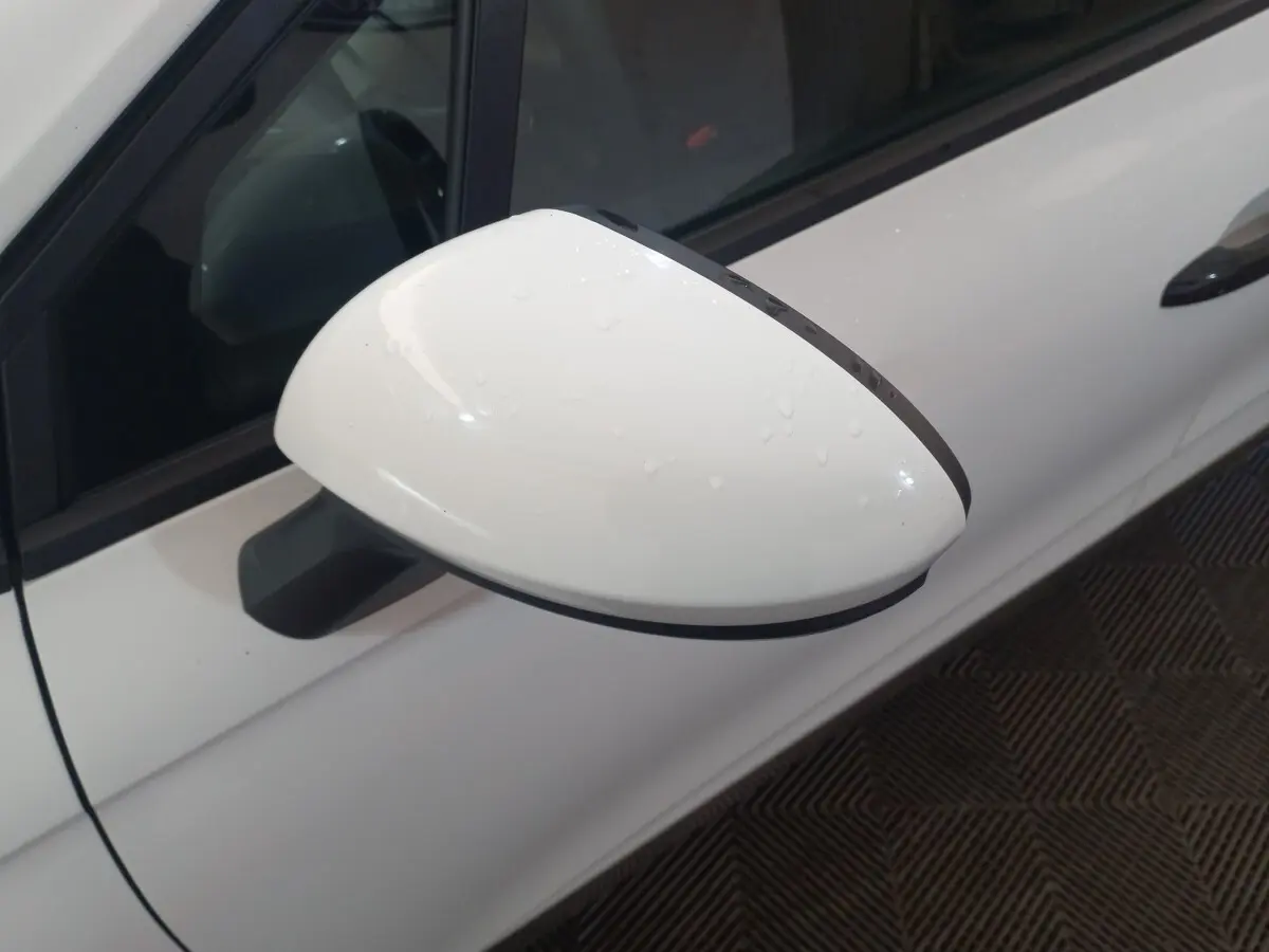 Rétroviseur droit blanc de Renault Clio Business 2021 avec gouttes d'eau, vue rapprochée côté conducteur.