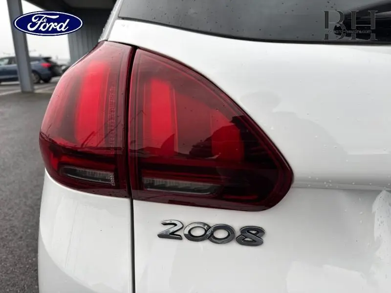 Gros plan sur le feu arrière gauche et le logo 2008 d'un Peugeot 2008 blanc Banquise, arrière du véhicule visible.