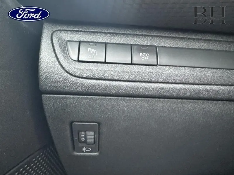 Détail des commandes noires de désactivation du radar de stationnement et mode ECO sur Peugeot 2008 blanc Banquise.