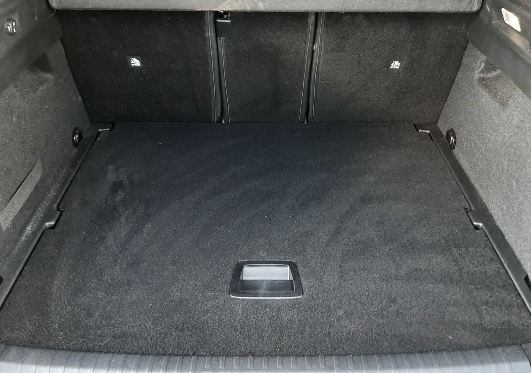 Vue intérieure du coffre spacieux et propre du Peugeot 3008 1.2 Hybrid 145ch GT bleu Ingaro, sans chargement.