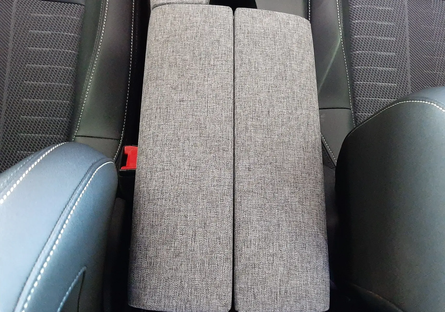 Vue plongeante sur la console centrale grise et les sièges bleu Ingaro du Peugeot 3008 1.2 Hybrid 145ch GT 2025.