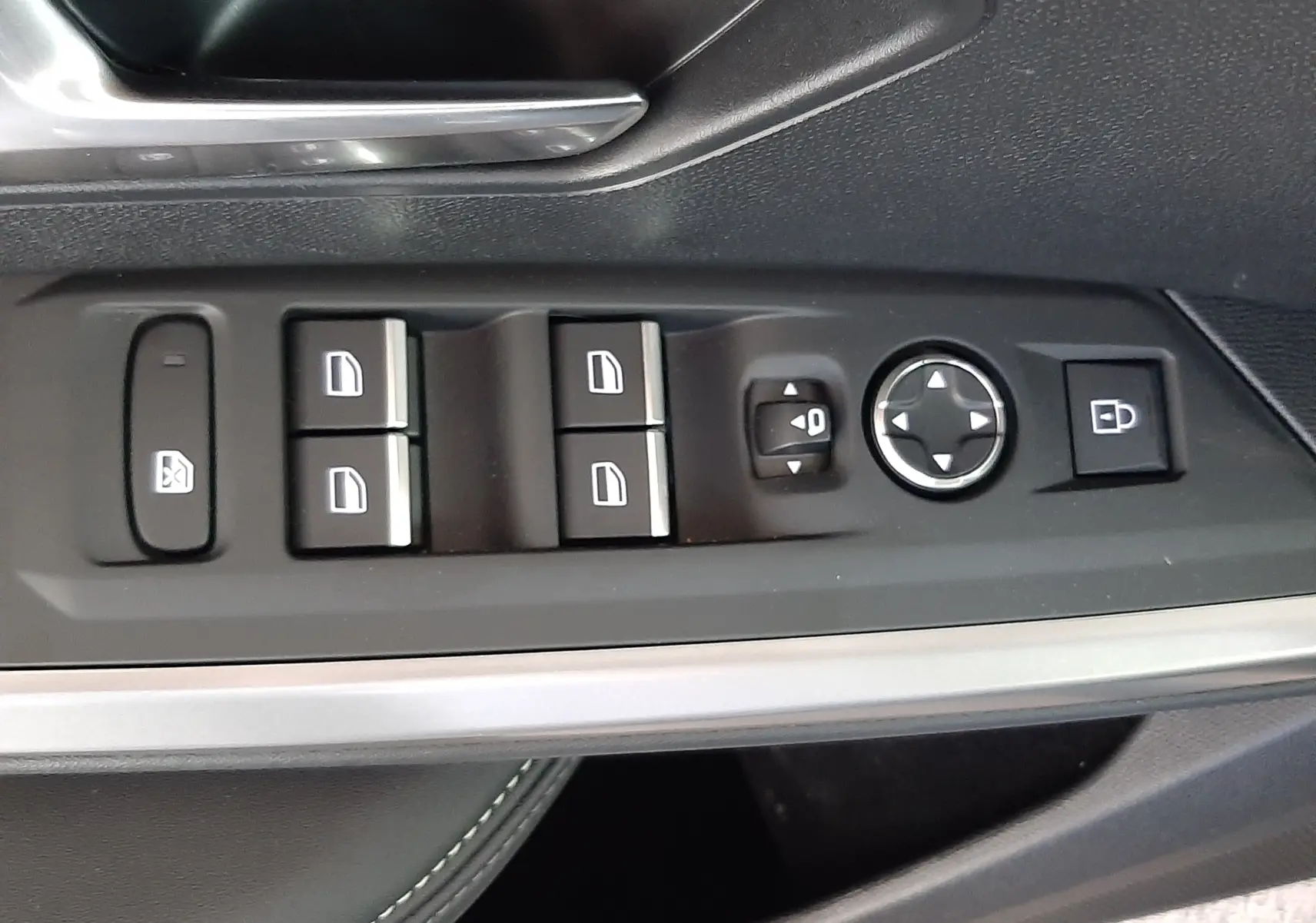 Vue rapprochée de la commande des vitres et rétroviseurs sur la porte côté conducteur du Peugeot 3008 bleu Ingaro 2025.