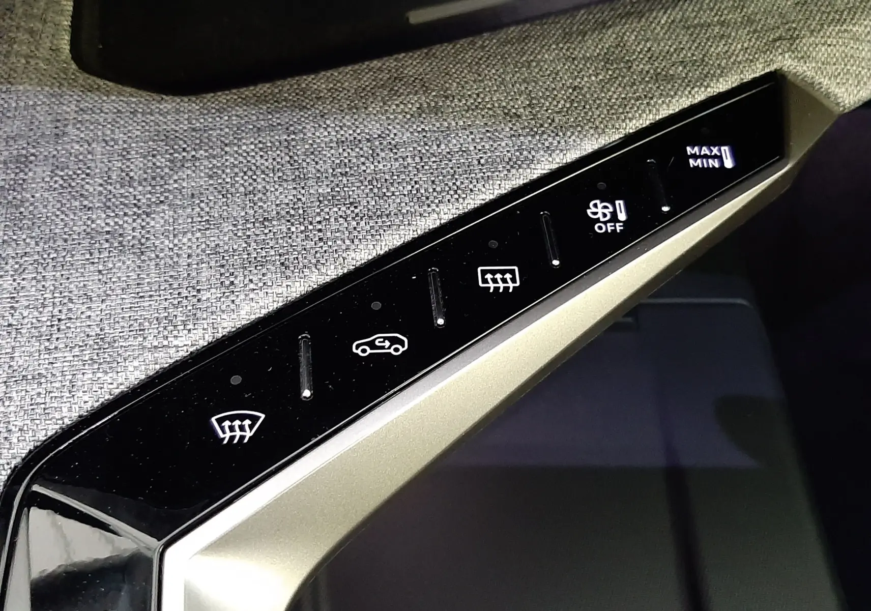 Détail du panneau de commande de climatisation tactile dans l’habitacle du Peugeot 3008 hybride 2025, finition GT.