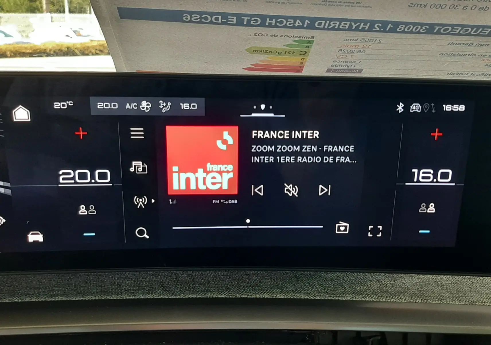 Vue rapprochée de l’écran tactile central du Peugeot 3008 hybride 2025, affichant la radio France Inter et la climatisation.