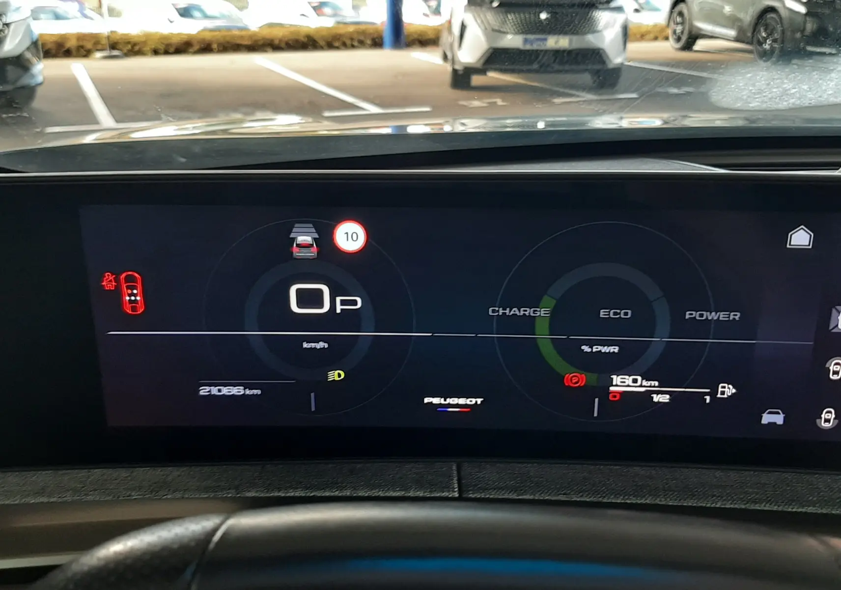 Vue intérieure du tableau de bord numérique du Peugeot 3008 Hybrid 2025, affichage moderne avec indicateurs de charge et vitesse.