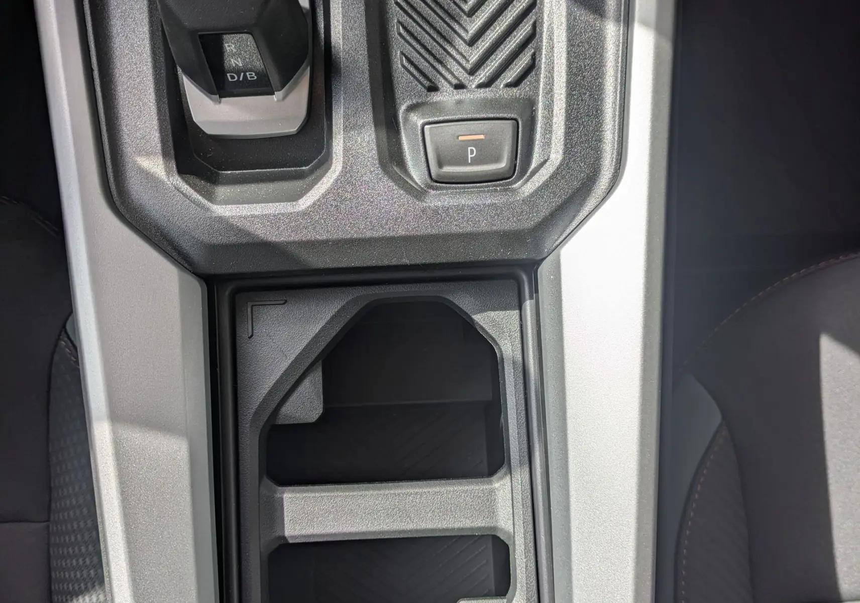 Vue plongeante sur la console centrale grise du Dacia Bigster Hybrid 155 Extreme, avec sélecteur de boîte auto et rangement intégré.