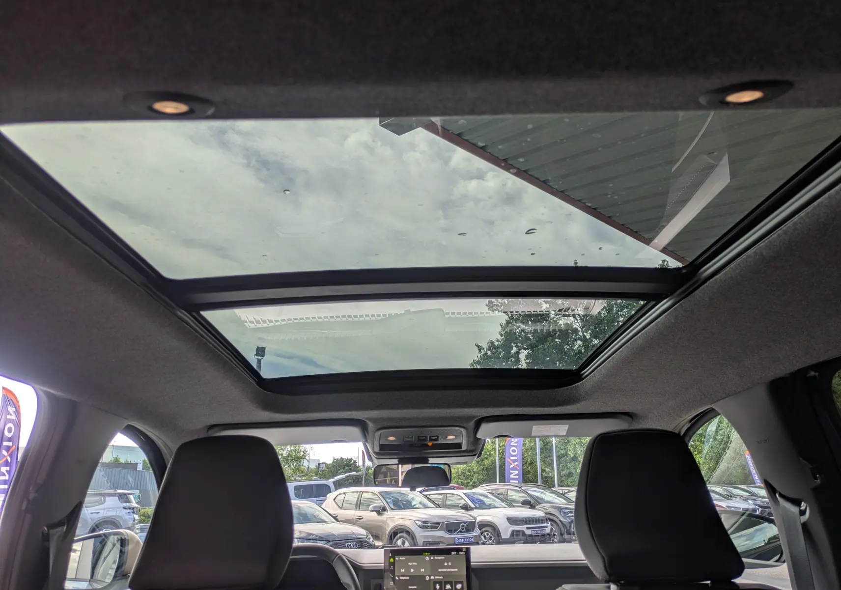 Vue intérieure du toit ouvrant panoramique du Dacia Bigster Hybrid 155 Extreme avec ciel visible à travers le verre.