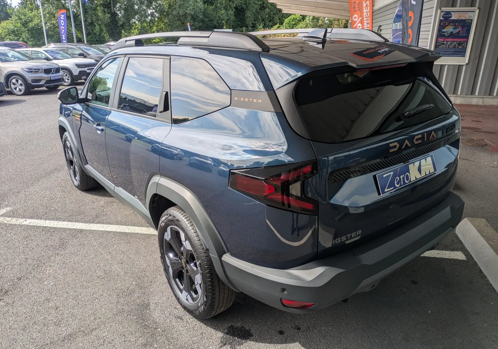 Vue 3/4 arrière droite du Dacia Bigster Hybrid 155 Extreme bleu indigo avec jantes alliage noires et hayon électrique.
