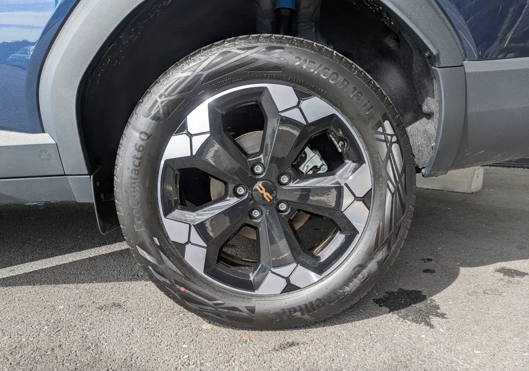 Gros plan sur la roue avant gauche du Dacia Bigster Hybrid 155 Extreme bleu indigo avec jante alliage diamantée 18 pouces.