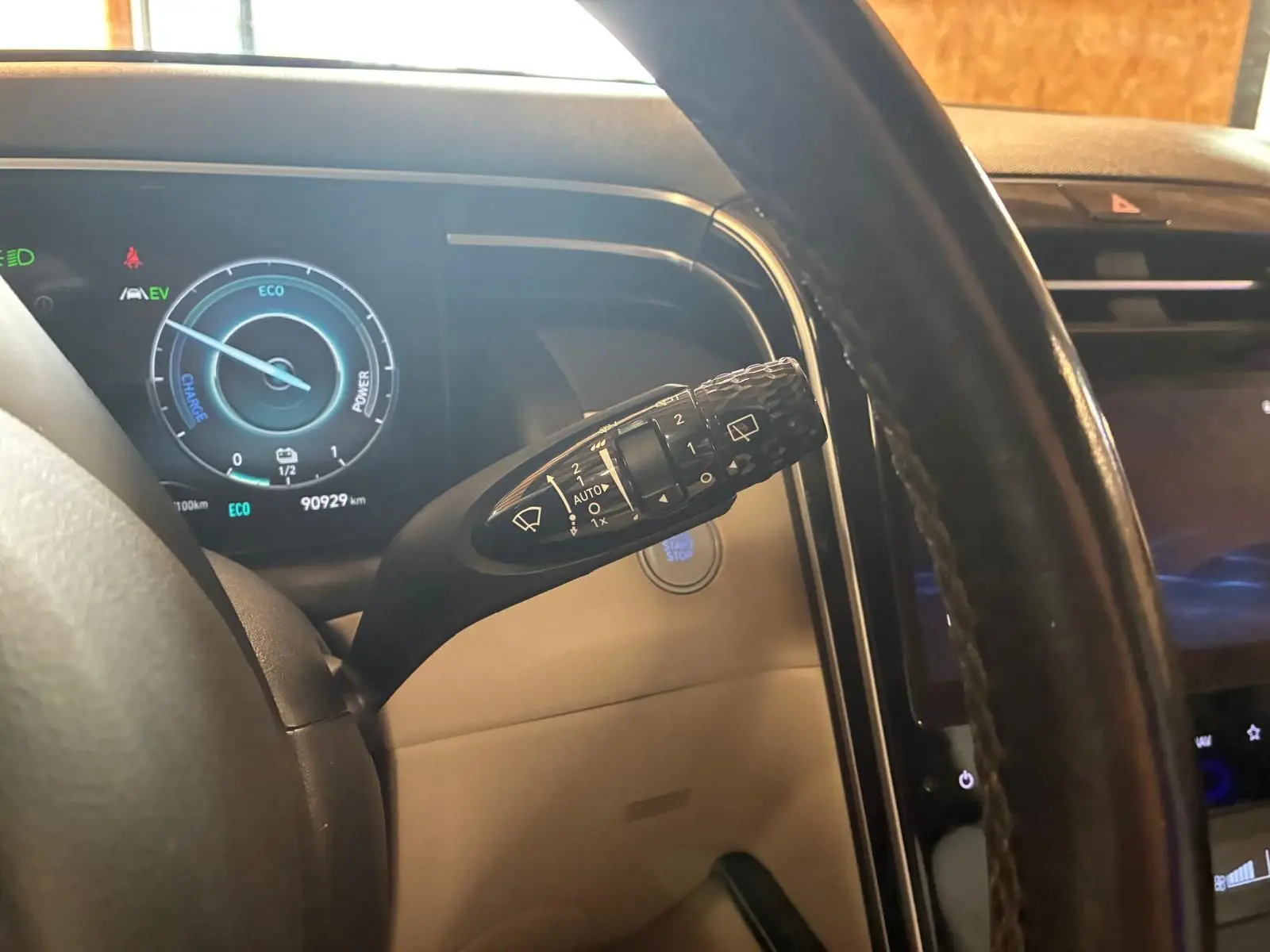 Vue rapprochée du tableau de bord et du commodo d’essuie-glace d’un Hyundai Tucson hybride 2022 avec intérieur beige.