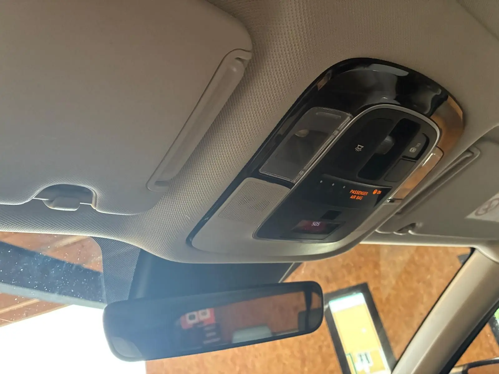 Vue intérieure du plafond avant du Hyundai Tucson noir 2022, avec commandes d'éclairage et rétroviseur central visible.
