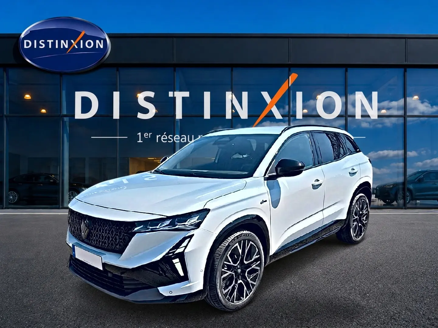 Renault Austral blanc nacré en 3/4 avant droit, avec jantes alu noires et toit noir contrasté devant showroom Distinxion.