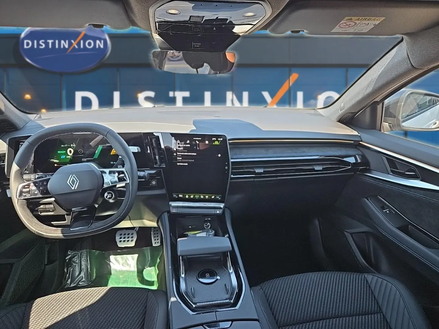 Vue intérieure avant du Renault Austral blanc nacré 2026, tableau de bord moderne avec écran tactile vertical et volant multifonctions.