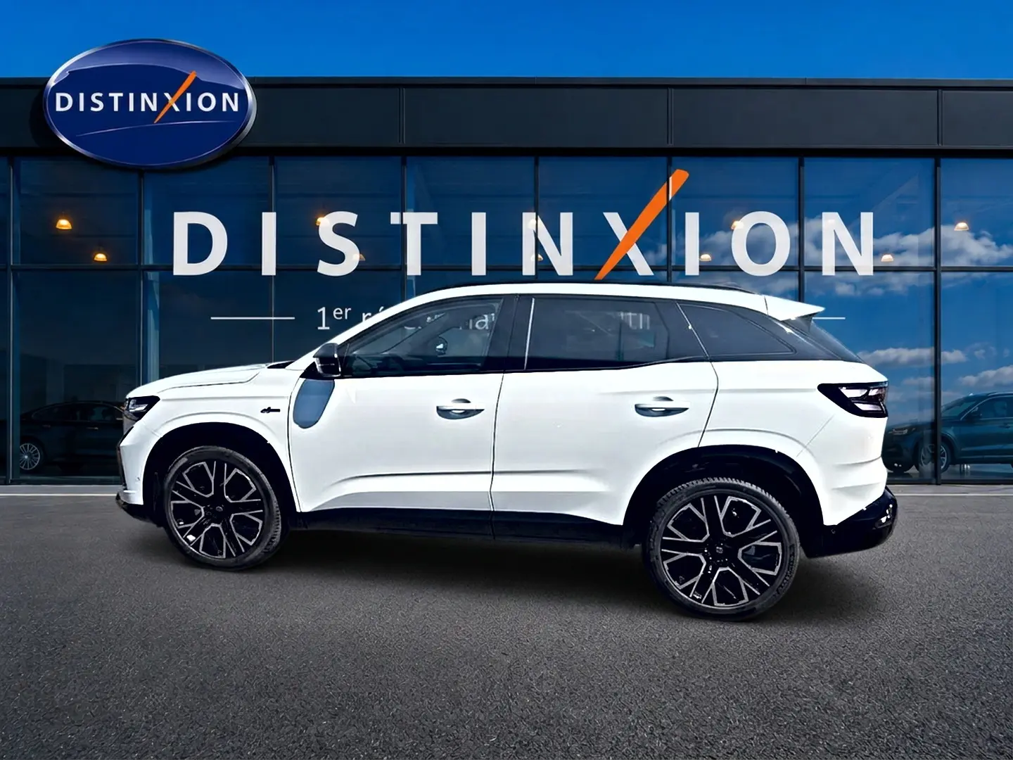 Renault Austral blanc nacré en profil droit, jantes alu noires et toit contrasté devant vitrine Distinxion.