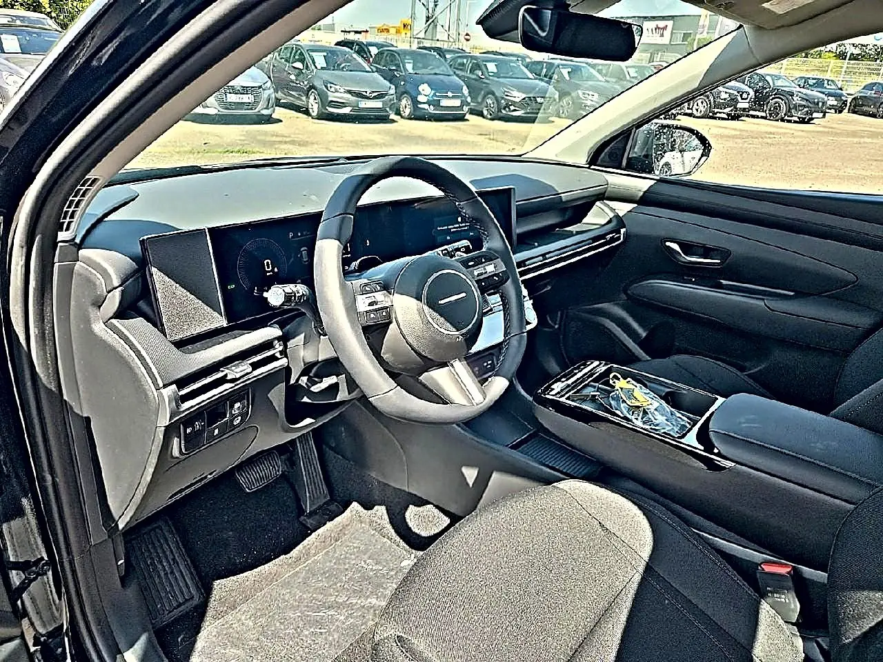 Vue intérieure côté conducteur du Hyundai Tucson noir 2026, mettant en valeur le tableau de bord digital et le volant multifonction cuir.