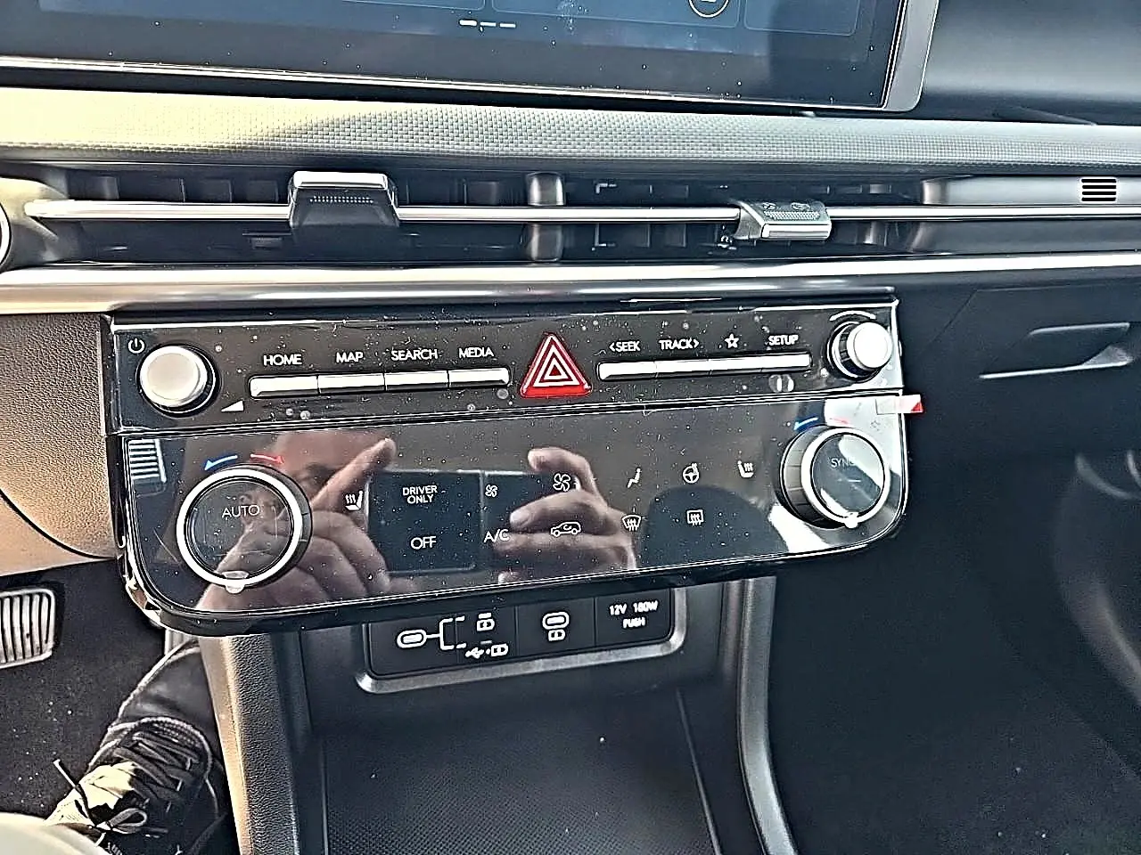 Vue rapprochée du tableau de bord noir du Hyundai Tucson 2026, avec commandes climatisation et multimédia.