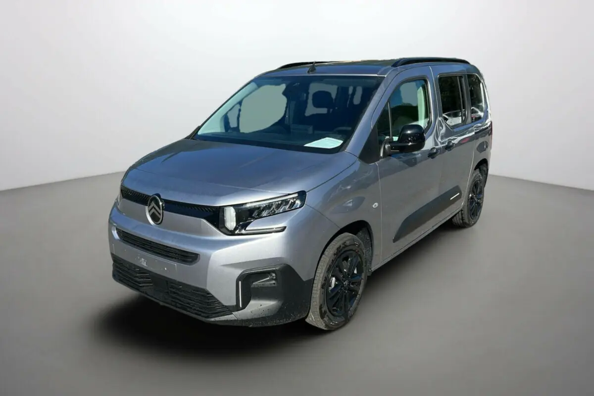 Citroën Berlingo 2025 gris Artense en 3/4 avant droit avec jantes alu noires et barres de toit visibles.