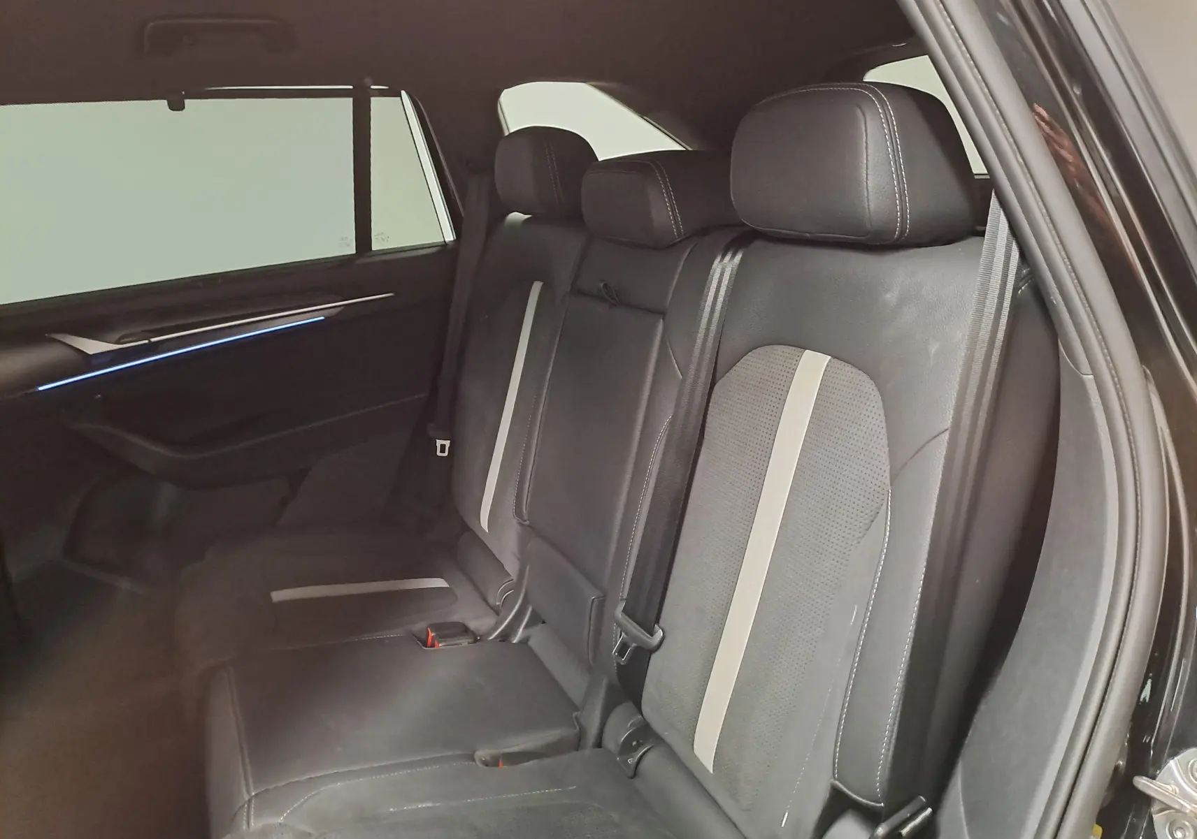 Vue intérieure côté droit des sièges arrière en cuir noir avec bandes grises du Skoda Kodiaq 2025 Noir Magic Nacré Sportline.
