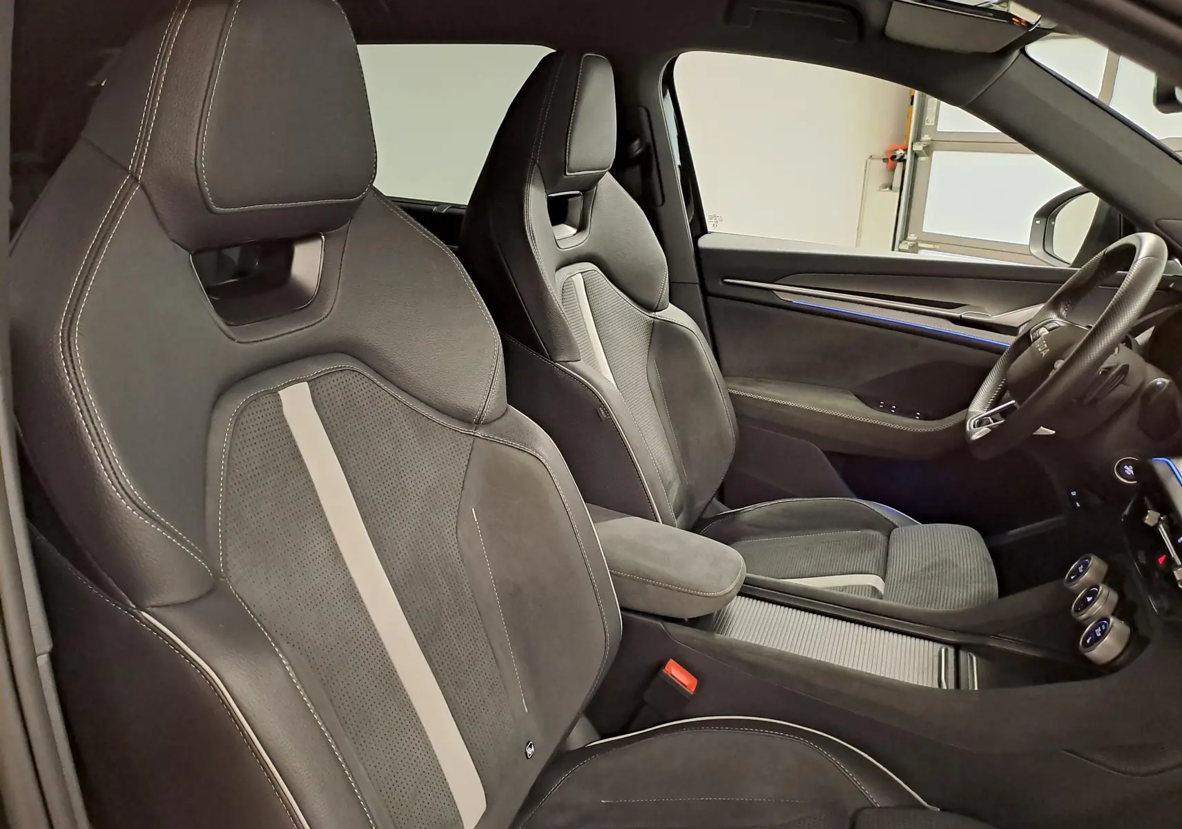 Vue intérieure côté droit montrant les sièges sport en cuir noir avec surpiqûres blanches du Skoda Kodiaq 2025 Sportline.