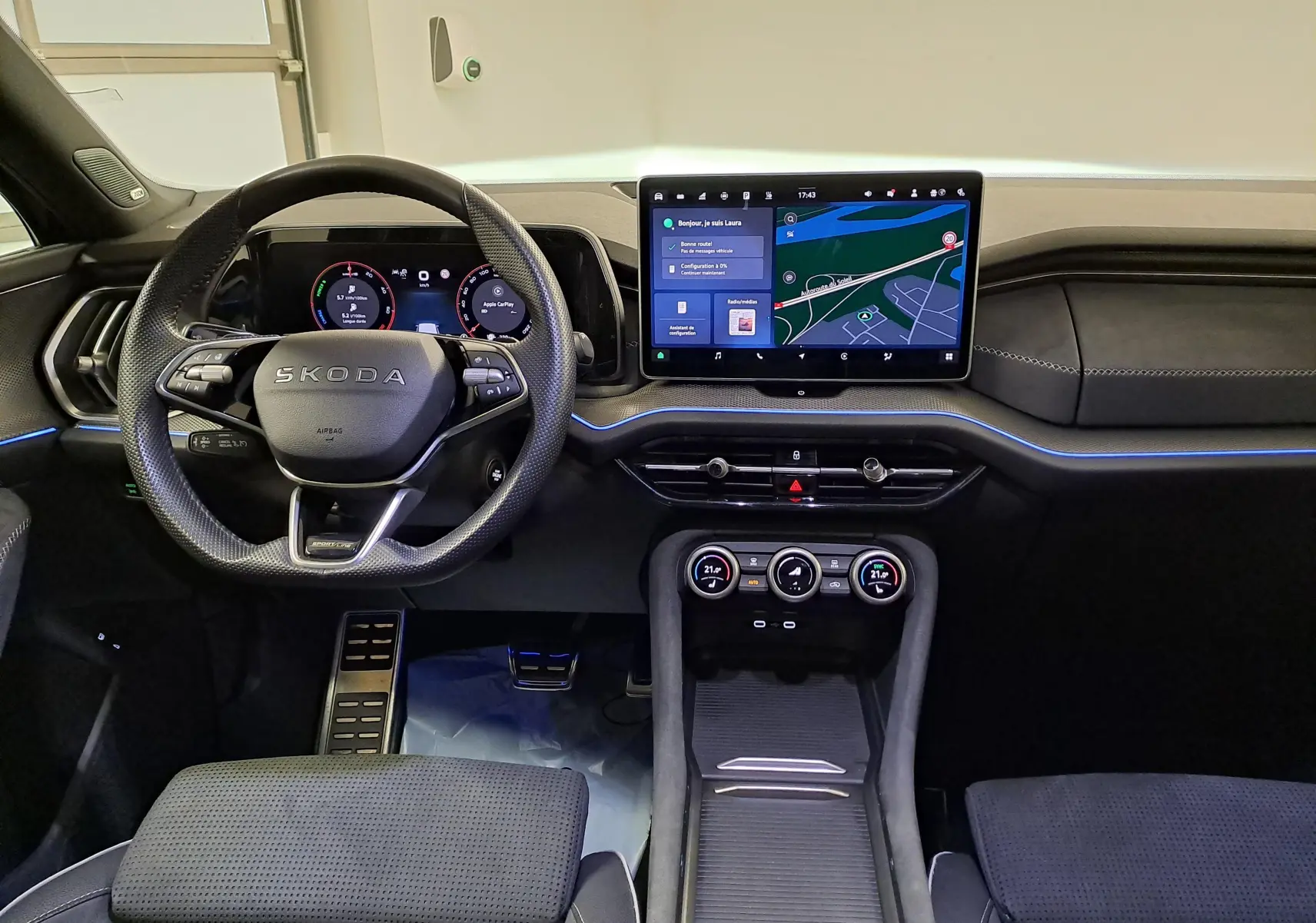 Vue intérieure avant du Skoda Kodiaq 2025, tableau de bord noir avec écran tactile central et volant multifonctions.