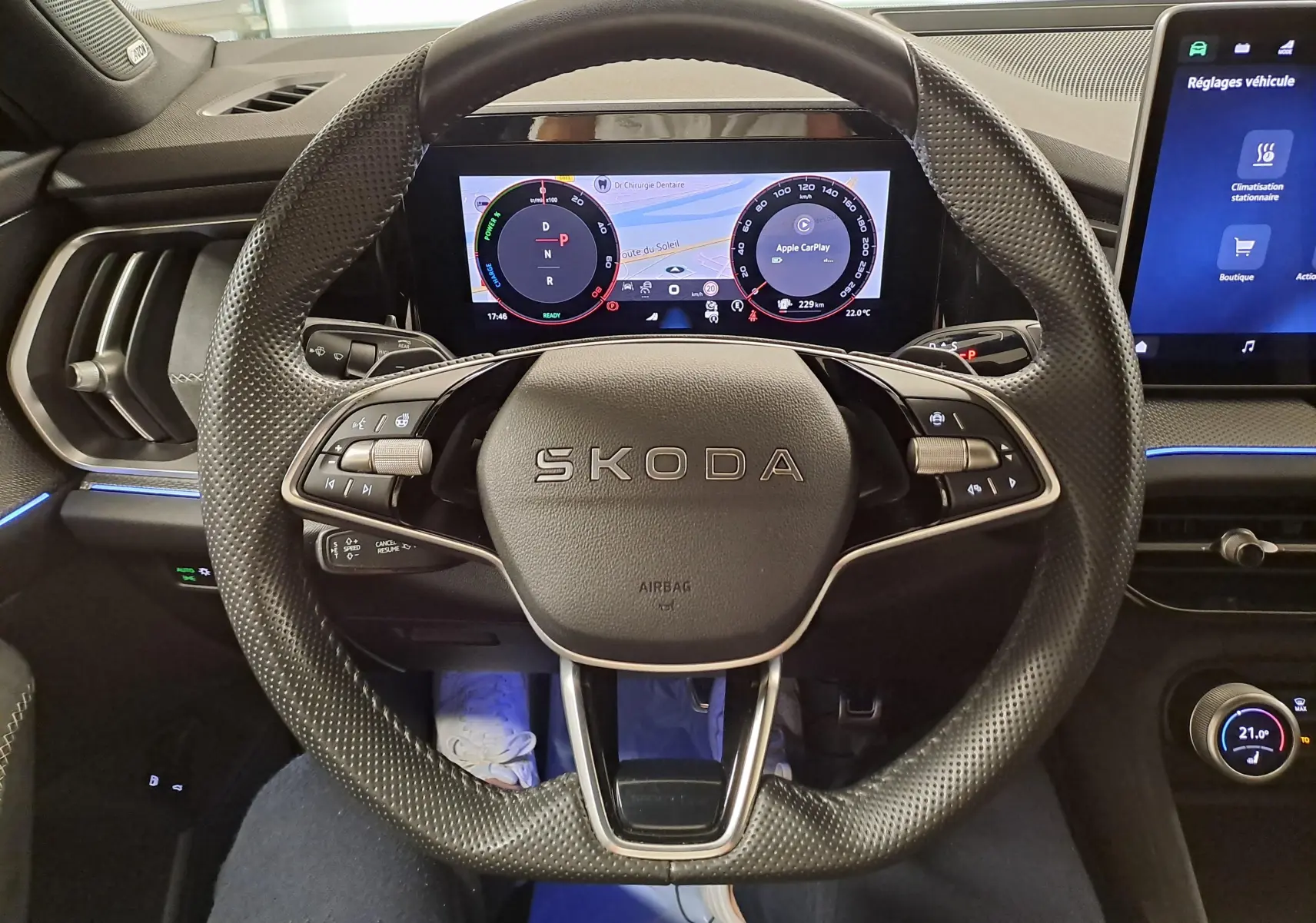 Vue rapprochée du volant perforé noir du Skoda Kodiaq 2025 avec tableau de bord numérique et écran tactile latéral.