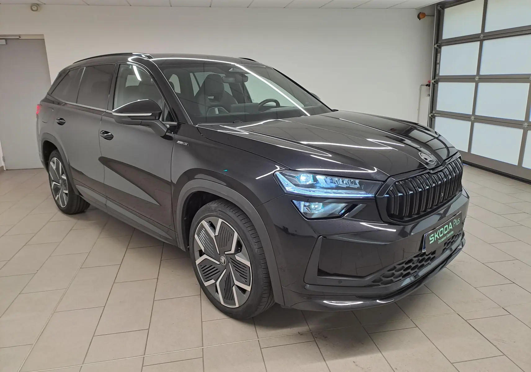 Vue 3/4 avant du Skoda Kodiaq noir Magic nacré avec calandre noire et jantes alliage 20 pouces anthracite.
