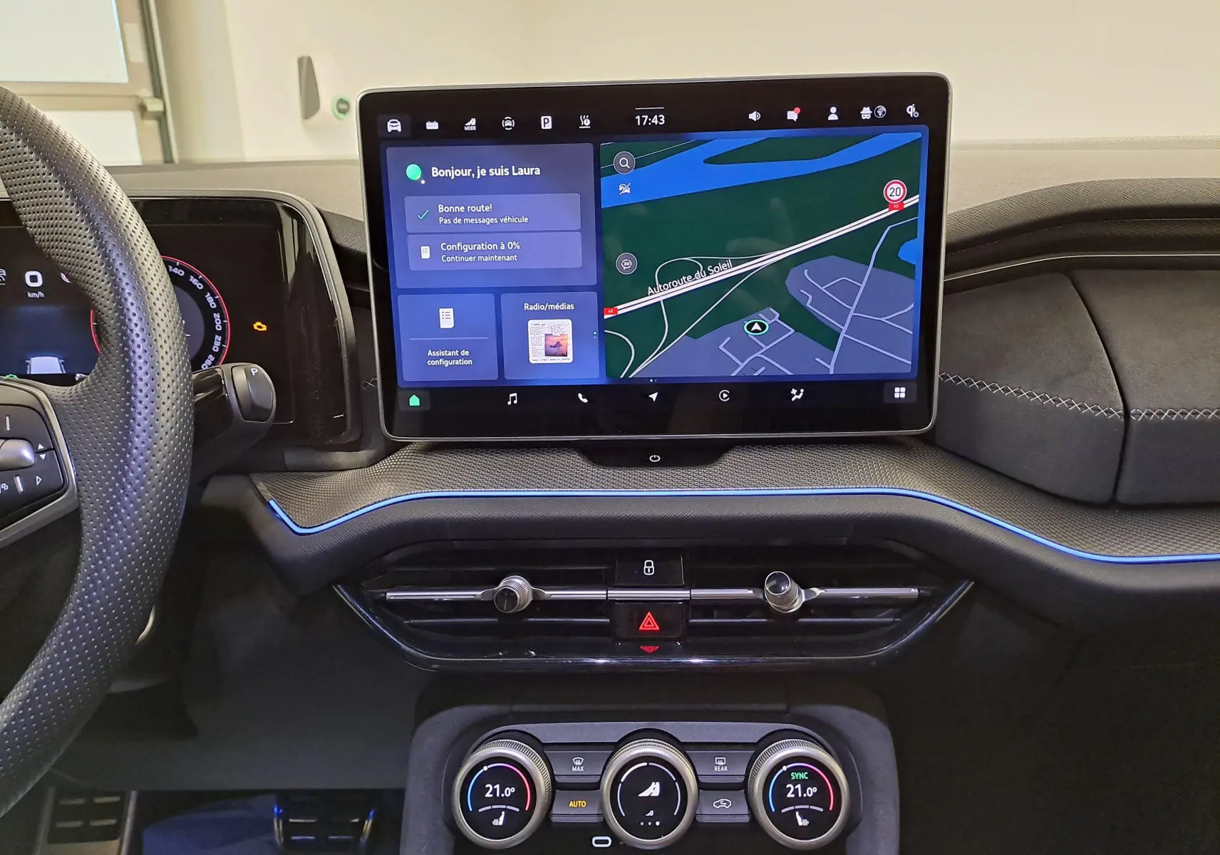 Vue intérieure du tableau de bord du Skoda Kodiaq 2025 avec écran tactile central et éclairage d'ambiance bleu.