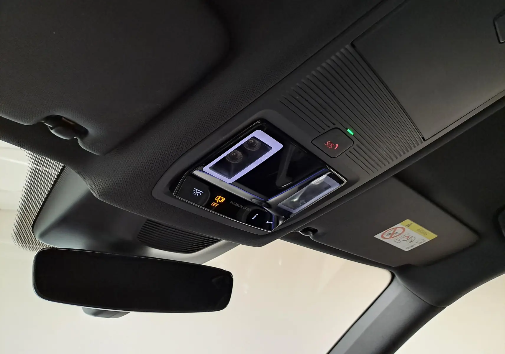 Plafonnier intérieur avec commandes lumineuses et bouton SOS, vue du poste de conduite du Skoda Kodiaq noir Magic nacré 2025.