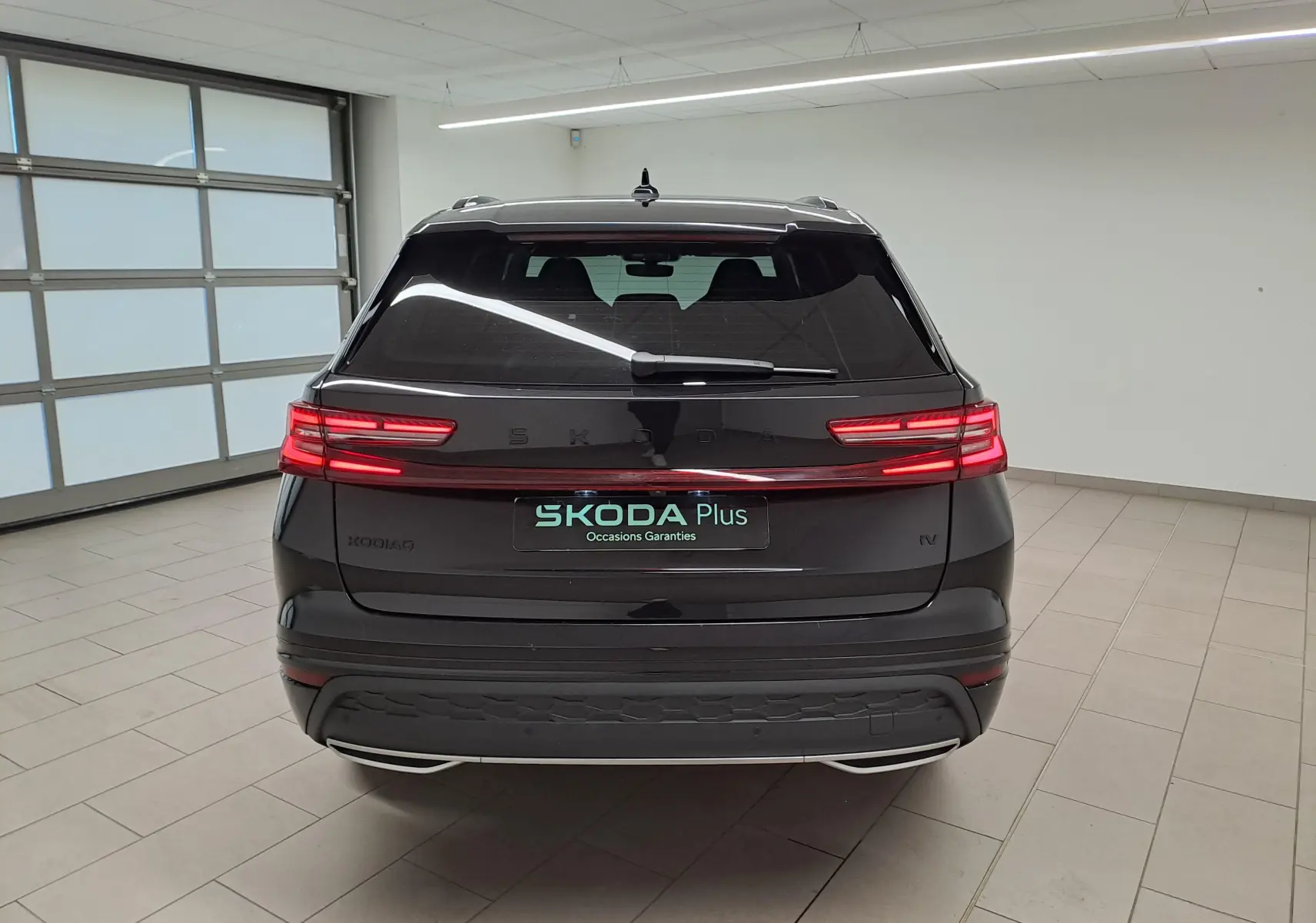 Vue arrière du Skoda Kodiaq noir Magic nacré, avec feux LED reliés par un bandeau lumineux horizontal.