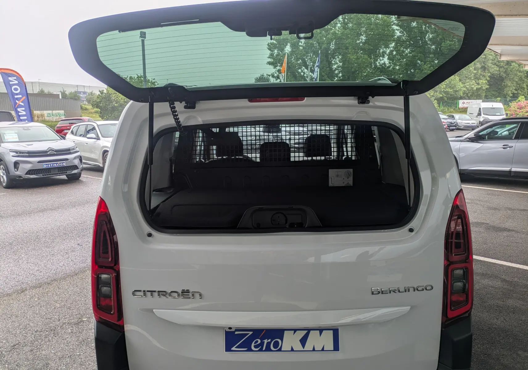 Vue arrière du Citroën Berlingo blanc 2025 avec hayon ouvert et séparation intérieure visible.