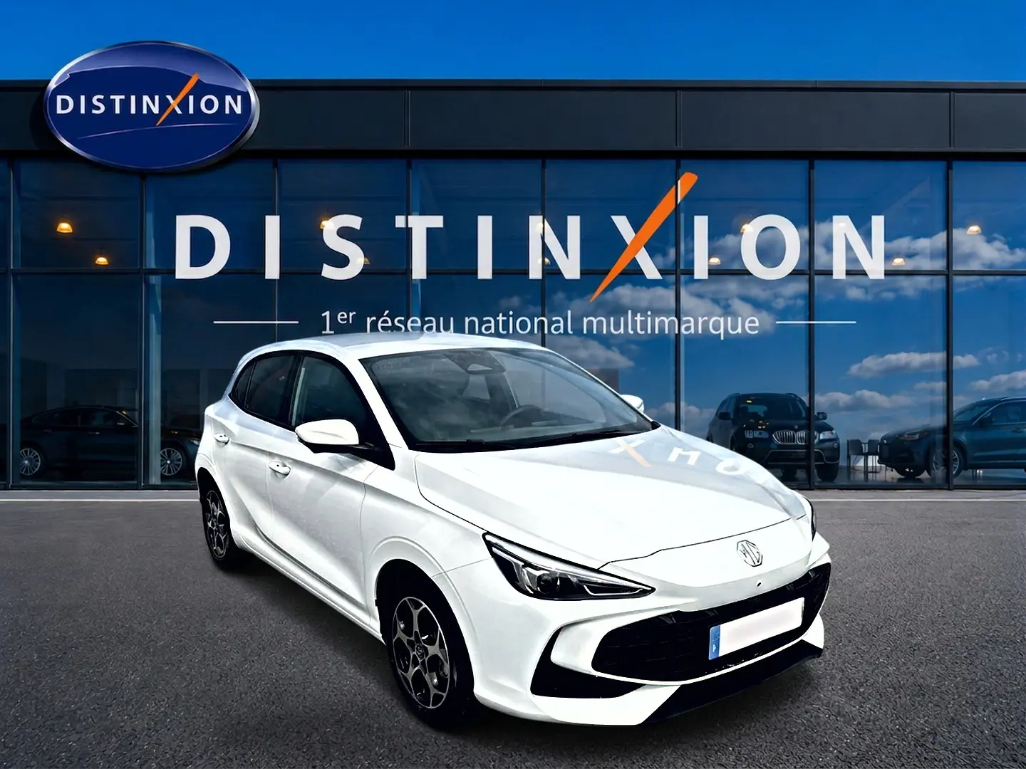 MG3 1.5 hybrid blanc en 3/4 avant droit, avec jantes alu et calandre noire, devant un showroom Distinxion.