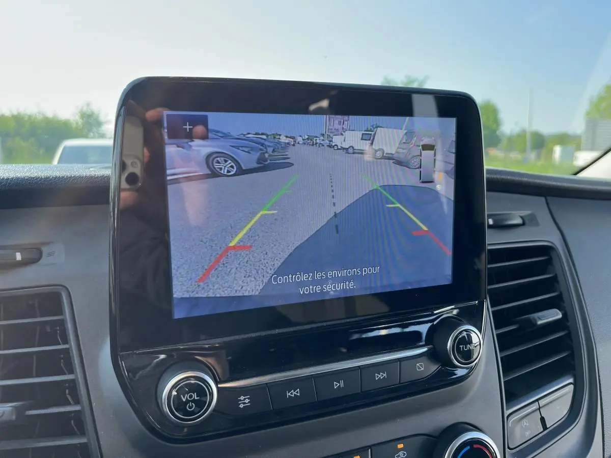 Écran tactile intérieur du Ford Transit Custom blanc de 2021 montrant la caméra de recul avec guidage coloré.