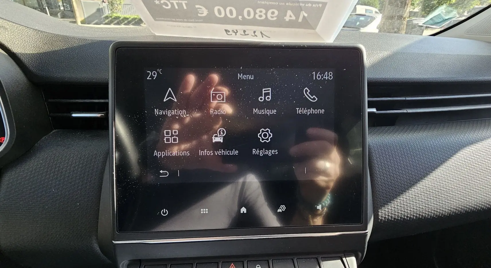 Écran tactile central du tableau de bord de la Renault Clio blanche, affichant le menu multimédia et navigation.