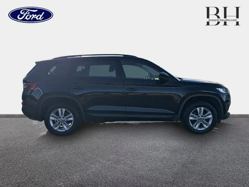 Profil côté gauche d'un Skoda Kodiaq noir Magic Nacré 2023, SUV 7 places avec jantes alliage visibles.