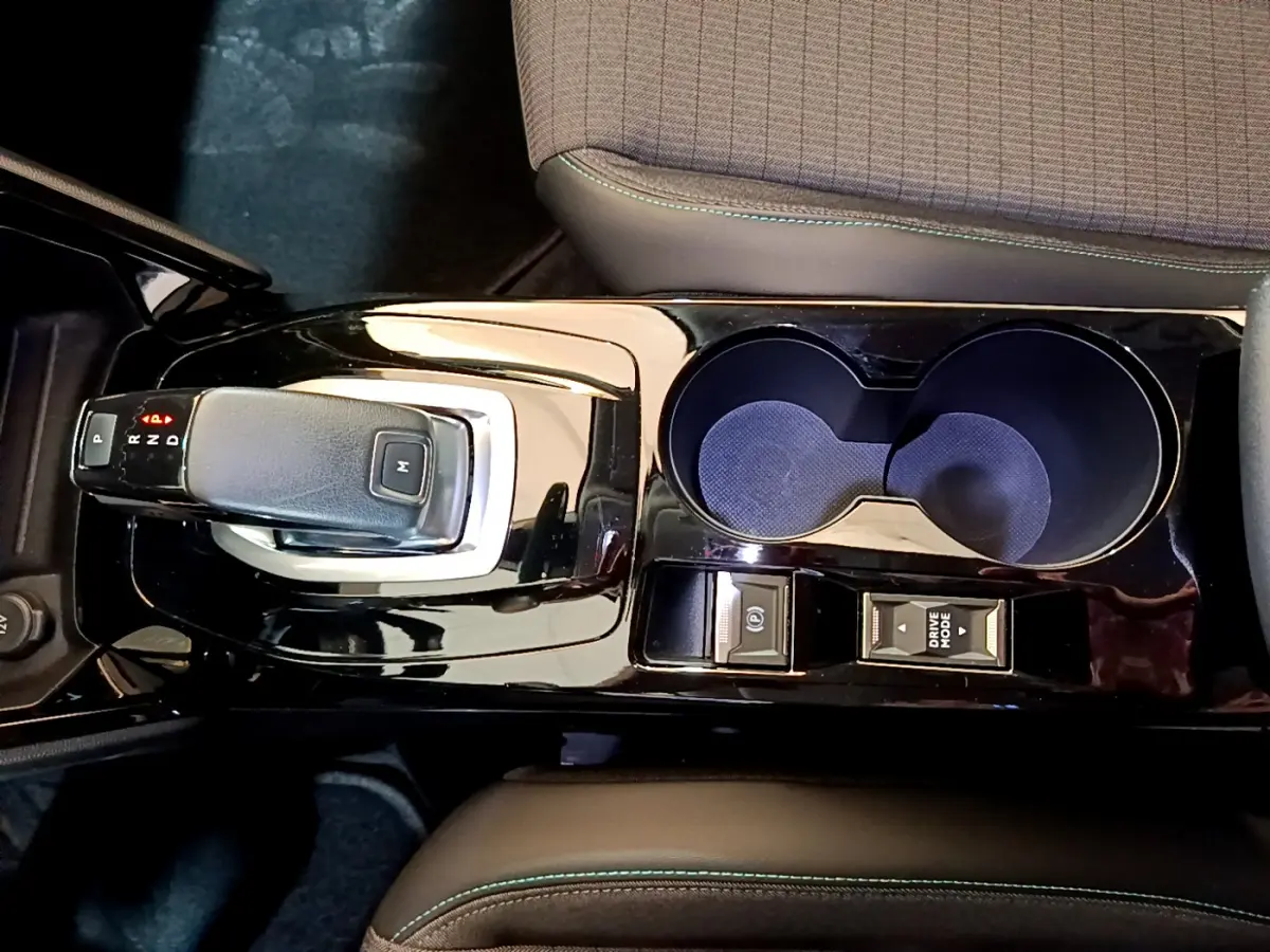 Vue plongeante sur la console centrale noire brillante du Peugeot 2008 gris clair, avec levier de vitesses automatique et porte-gobelets.