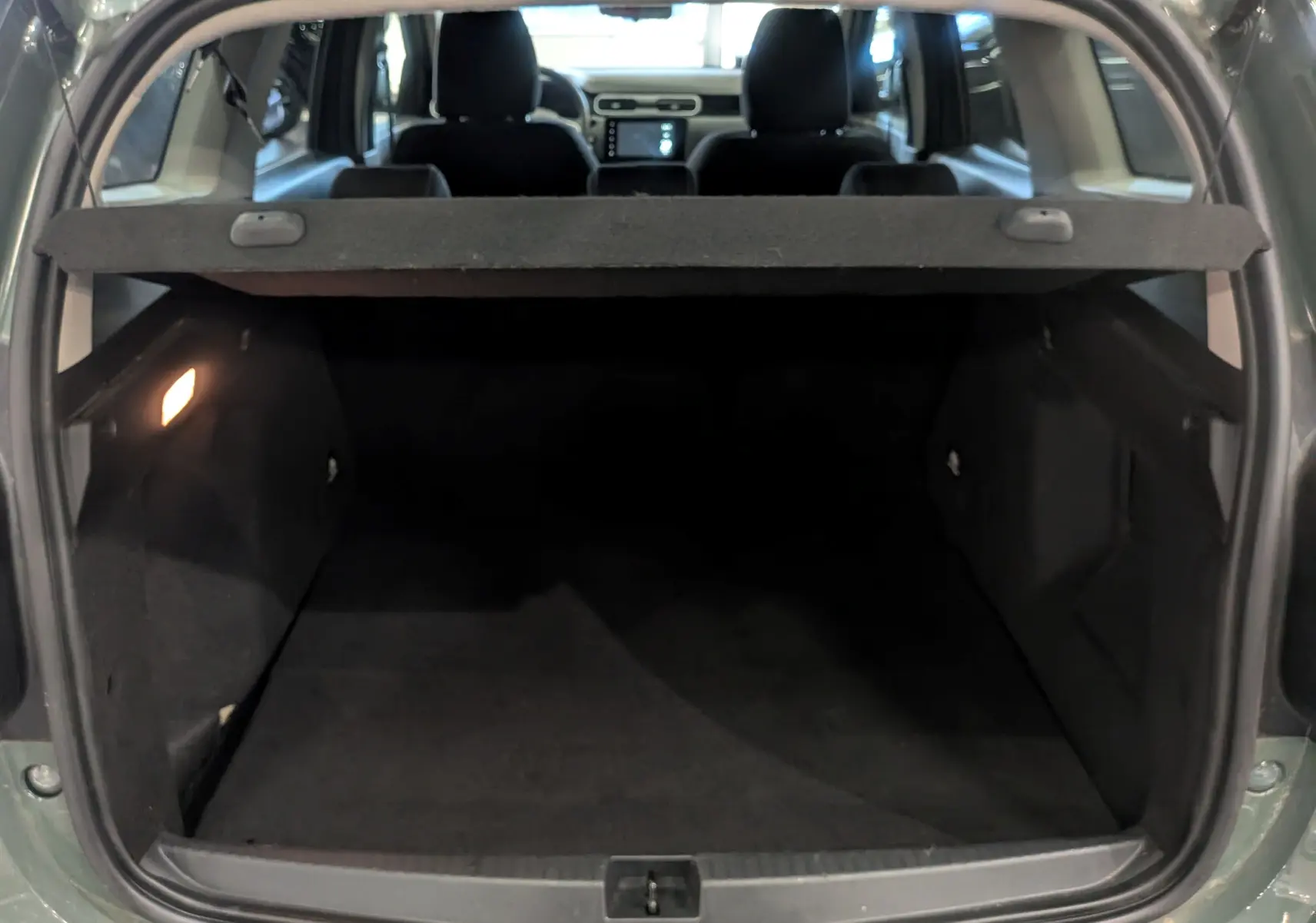 Coffre ouvert du Dacia Duster 2023 Kaki Lichen, vue arrière montrant l’espace de chargement et l’intérieur sombre.