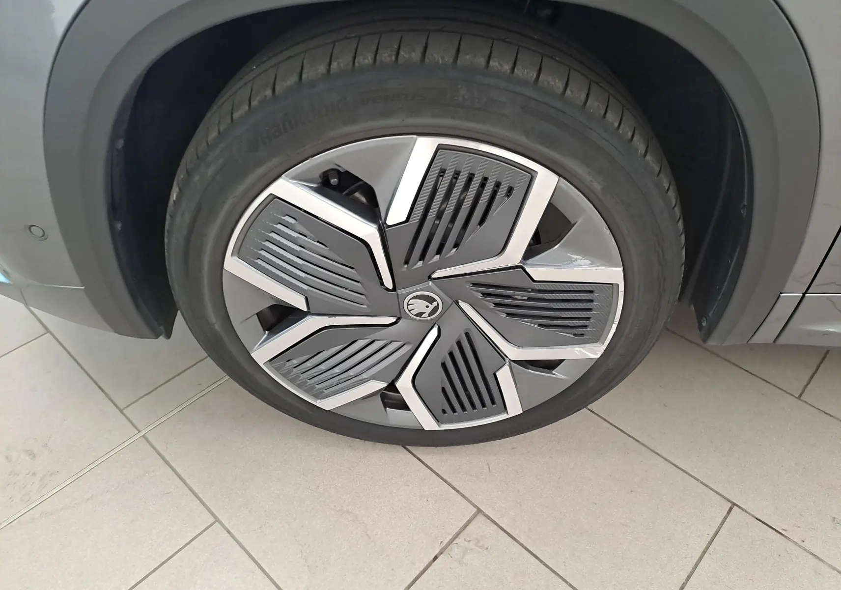 Gros plan sur la jante alliage 20'' anthracite avec enjoliveur noir du Skoda Kodiaq gris graphite, roue avant droite.