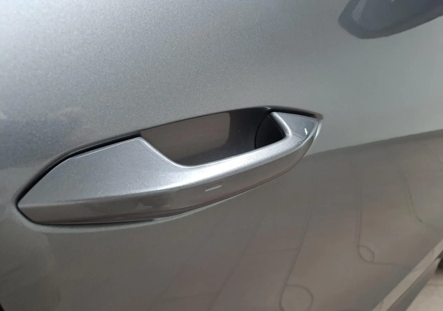 Poignée de porte gris graphite en gros plan sur le côté gauche du Škoda Kodiaq 2025 hybride rechargeable.