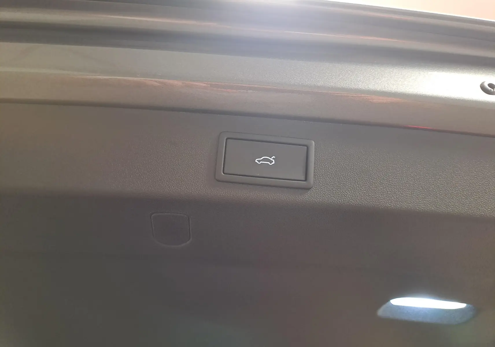 Gros plan sur le bouton d'ouverture électrique du hayon intérieur du Skoda Kodiaq Gris Graphite 2025.