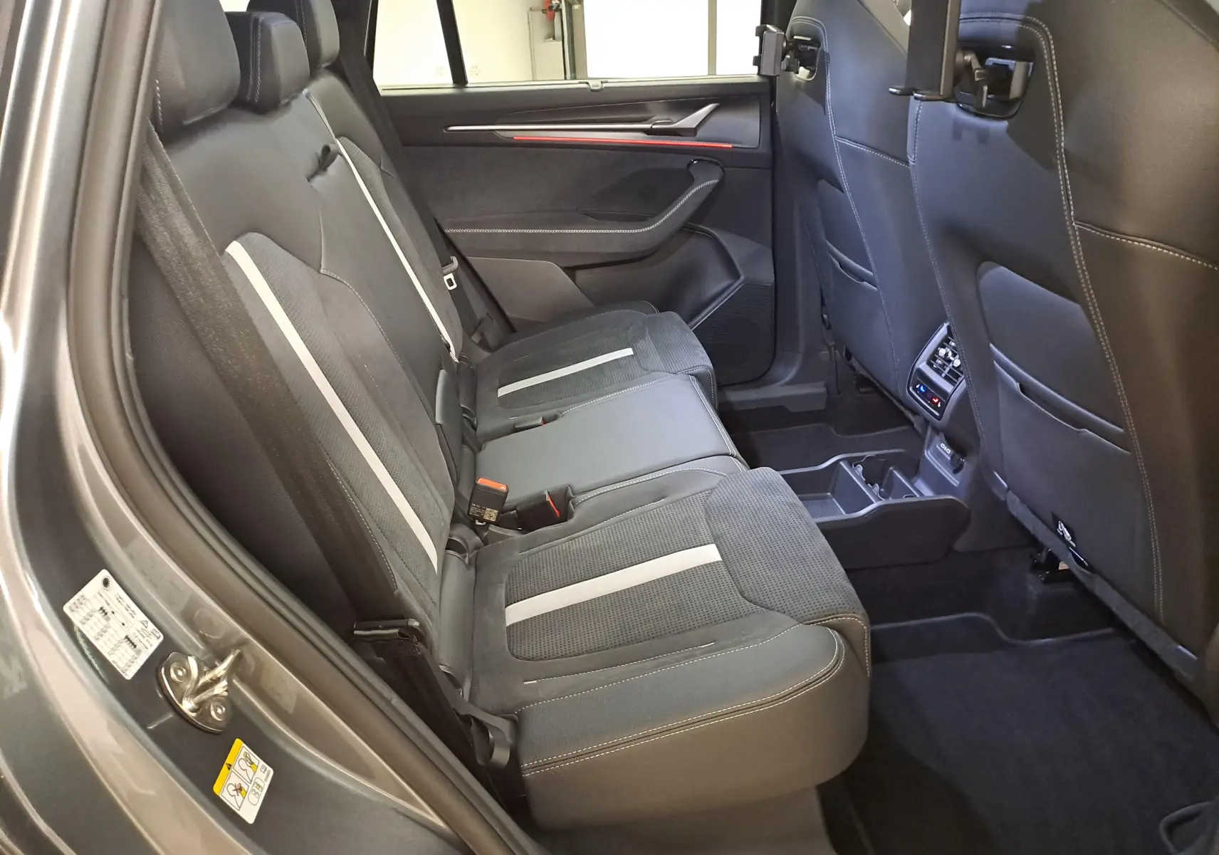 Vue intérieure côté droit des sièges arrière en tissu noir avec bandes grises du Skoda Kodiaq 2025 Gris Graphite Sportline.