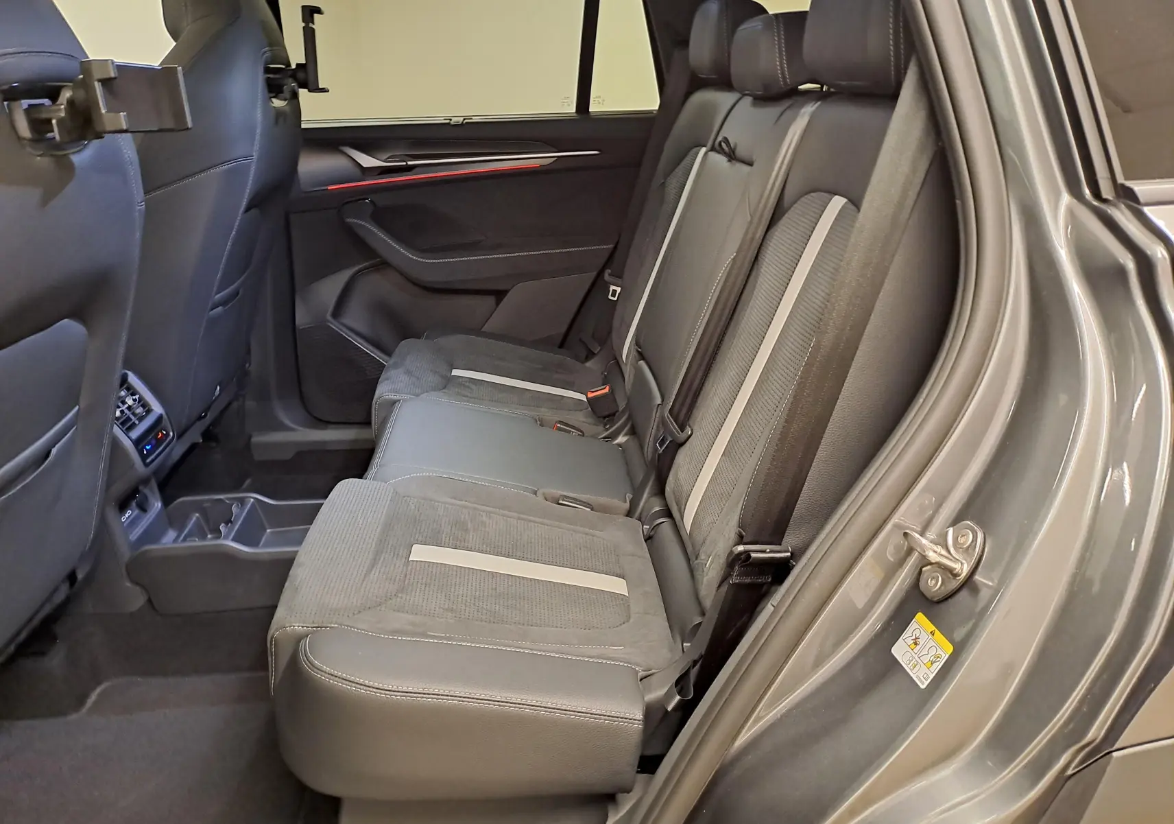 Vue intérieure côté droit des sièges arrière gris du Skoda Kodiaq 2025 avec finitions en tissu et cuir.