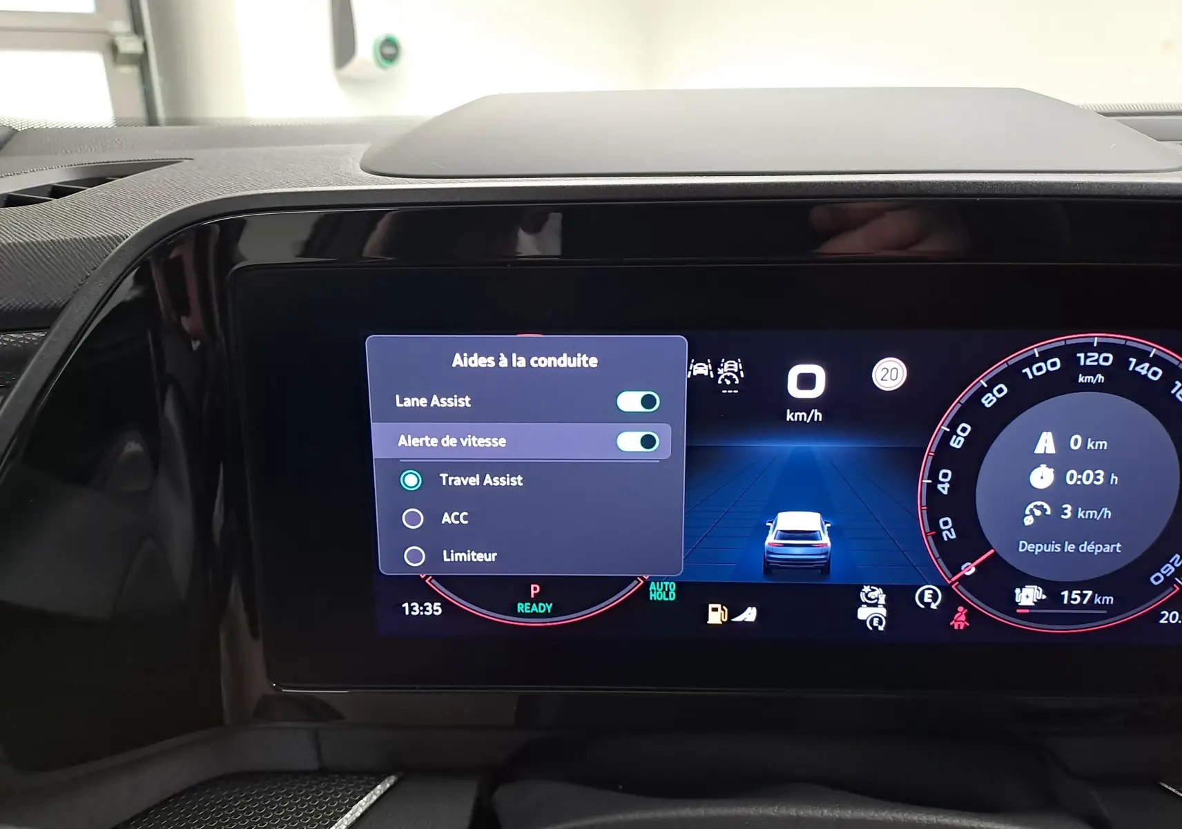 Vue rapprochée de l'écran digital du tableau de bord du Skoda Kodiaq gris graphite, affichant les aides à la conduite activées.