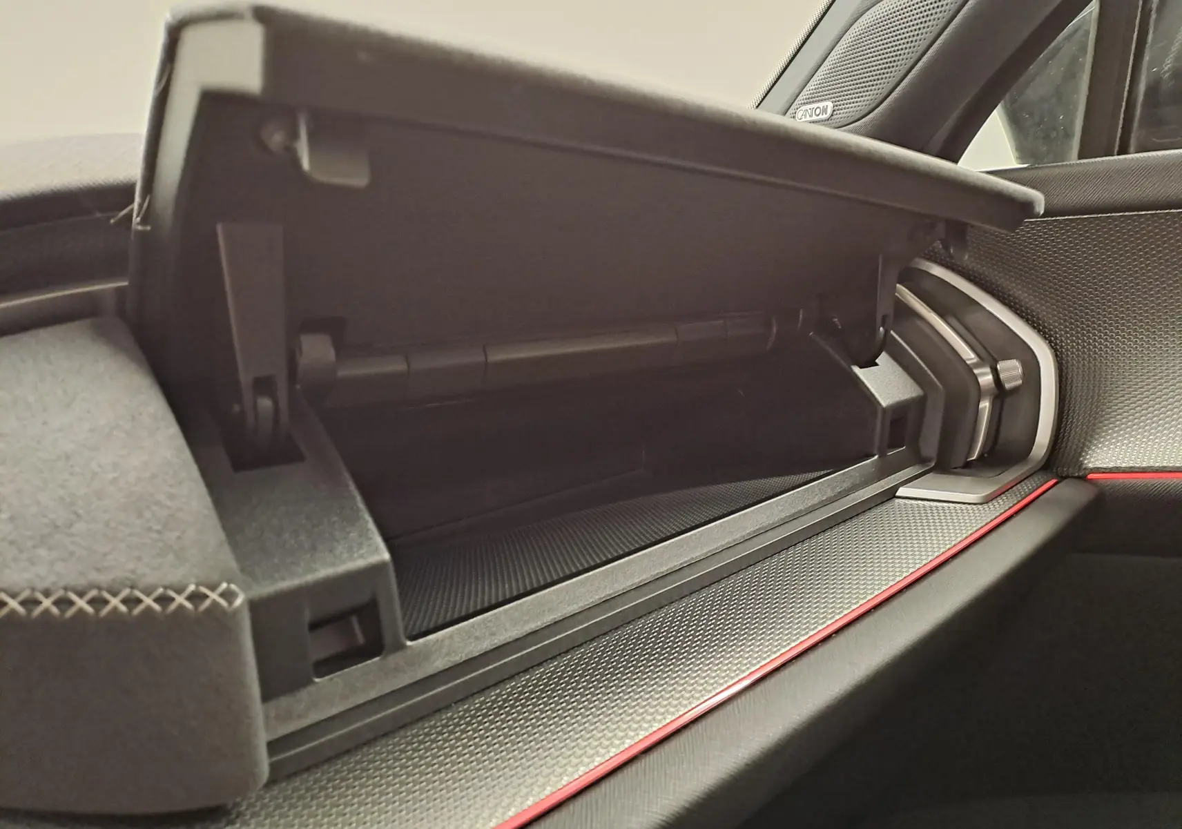 Vue rapprochée de la boîte à gants ouverte côté passager du Skoda Kodiaq gris graphite, avec détails de la planche de bord et surpiqûres.
