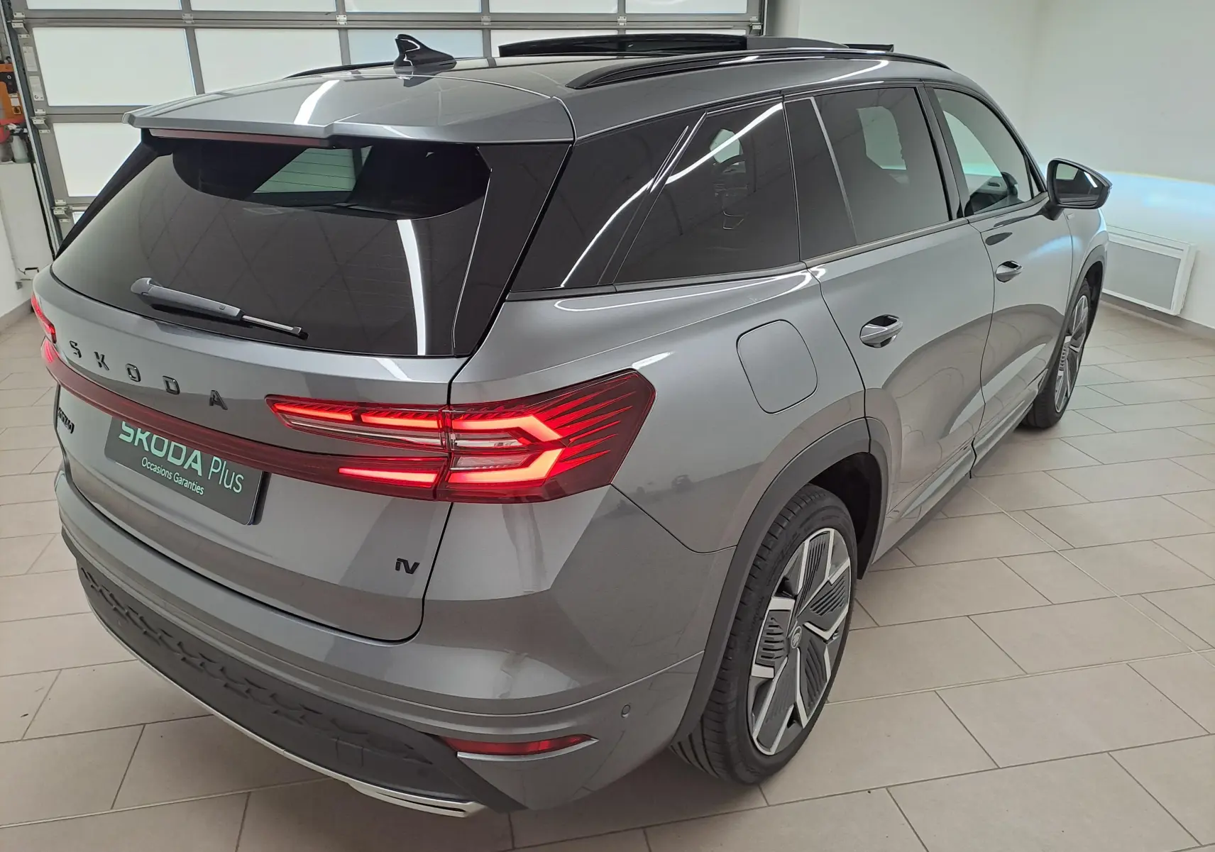 Vue 3/4 arrière droite du Skoda Kodiaq gris graphite avec feux arrière LED allumés et jantes alliage 20 pouces.