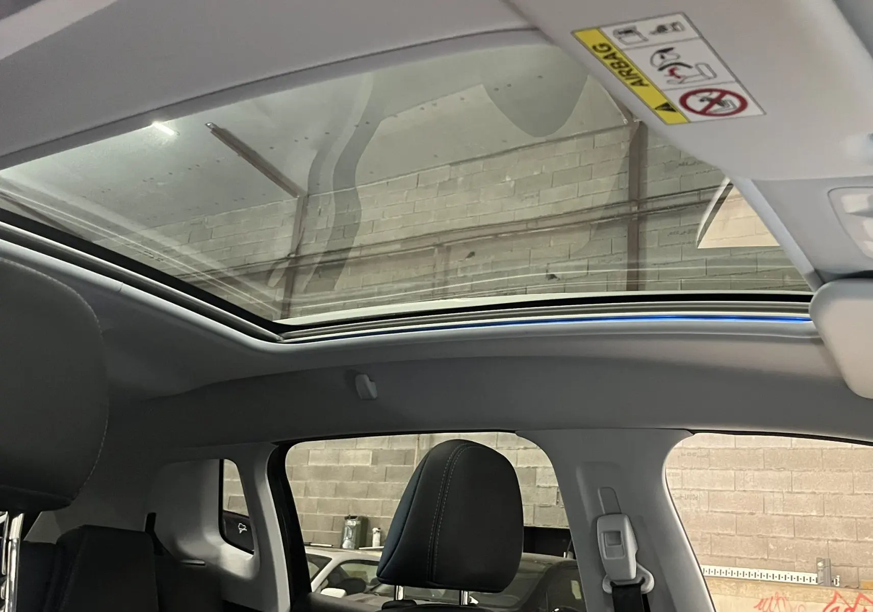 Vue intérieure du toit ouvrant panoramique du Peugeot 2008 noir, mettant en valeur les sièges avant en cuir noir.