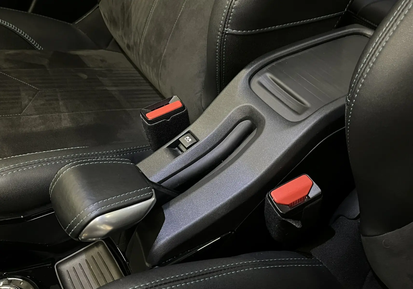 Vue rapprochée de la console centrale noire avec frein à main manuel et sièges en cuir noir du Peugeot 2008 Crossway 2018.