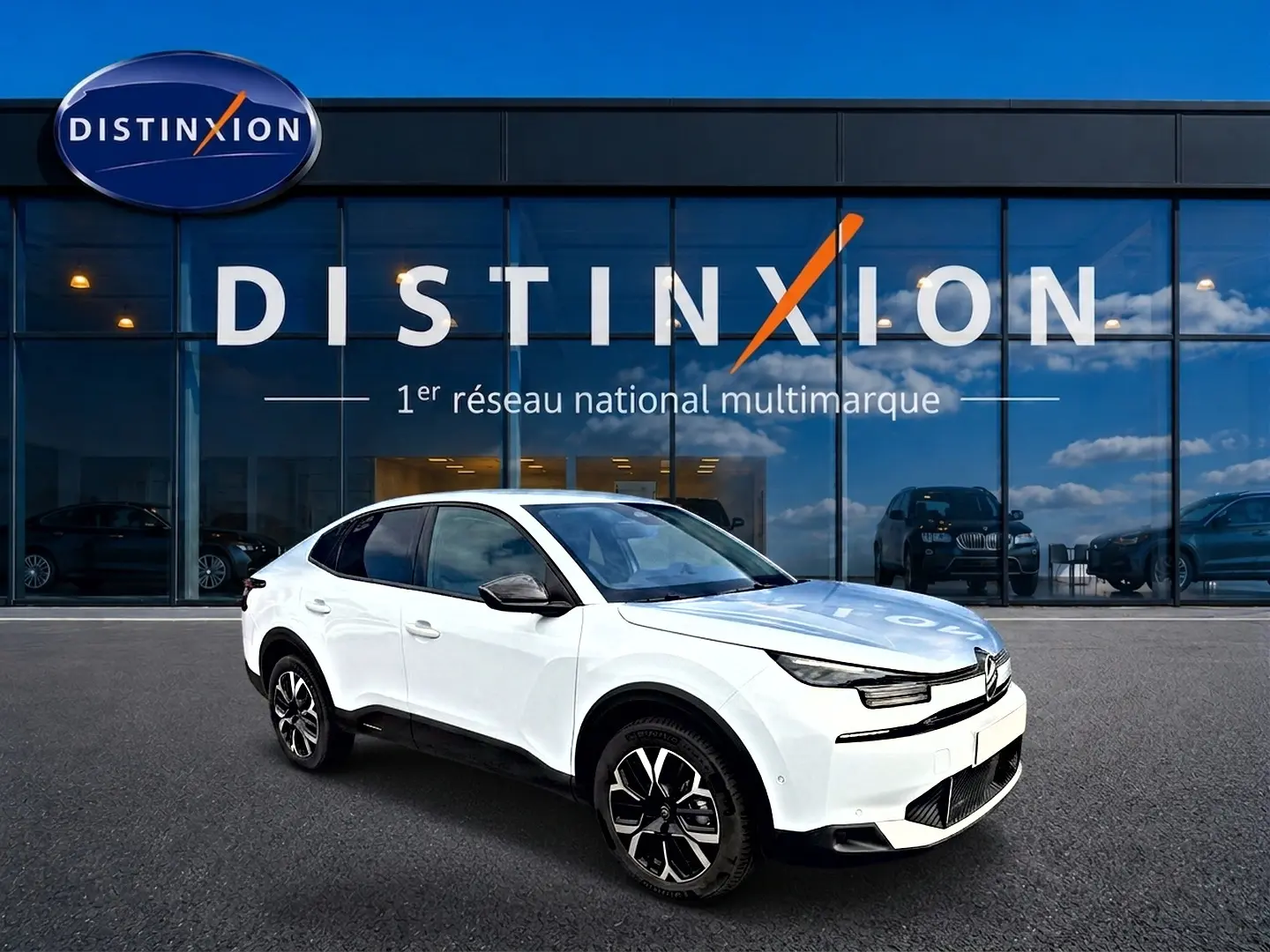 Citroën C4 X blanche vue en 3/4 avant droit, avec jantes alu noires et toit noir contrasté devant showroom Distinxion.