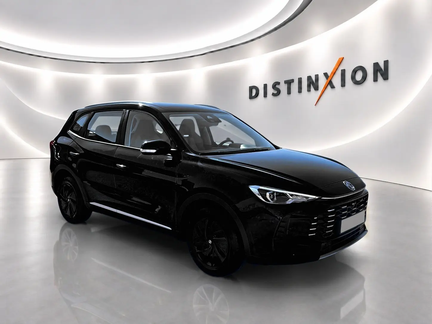 MG Motor ZS 1.5 hybrid noir en 3/4 avant droit, avec calandre marquée et jantes noires dans un showroom lumineux.