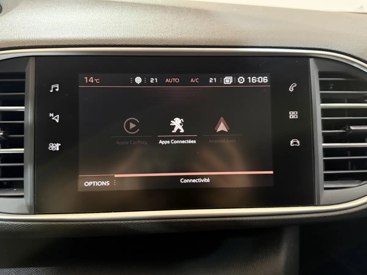 Écran tactile central affichant les applications connectées dans l’habitacle d’une Peugeot 308 noire de 2020.